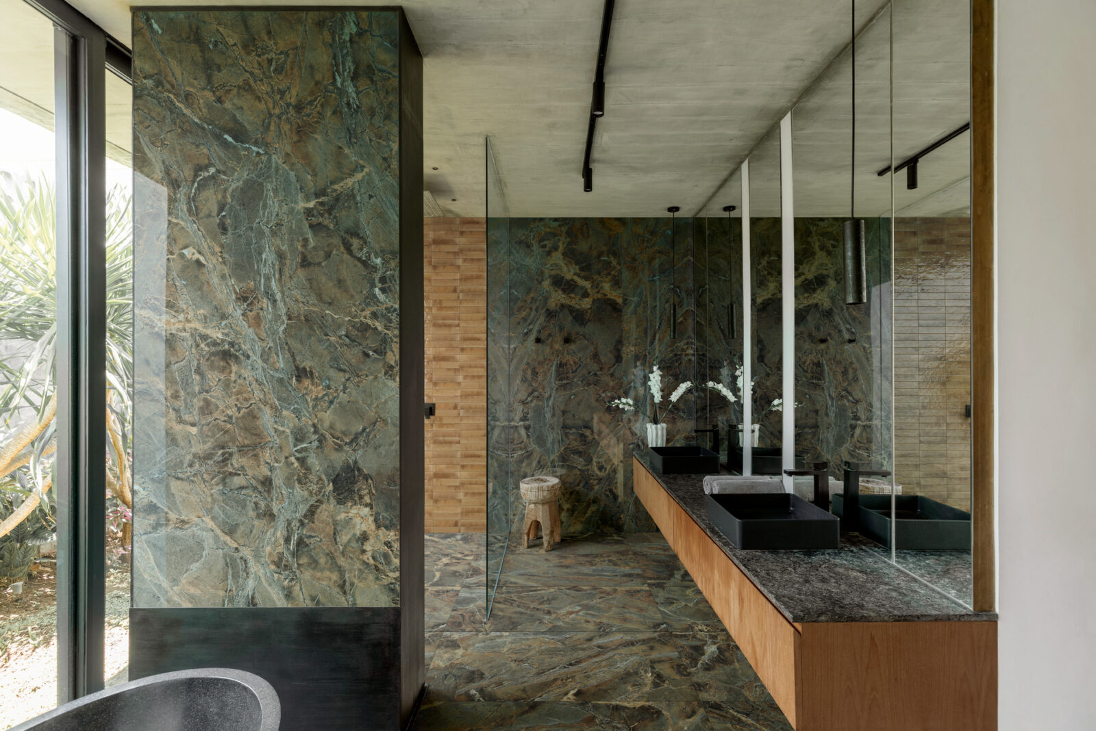 Green marble bathroom with feature tiles and freestanding bath